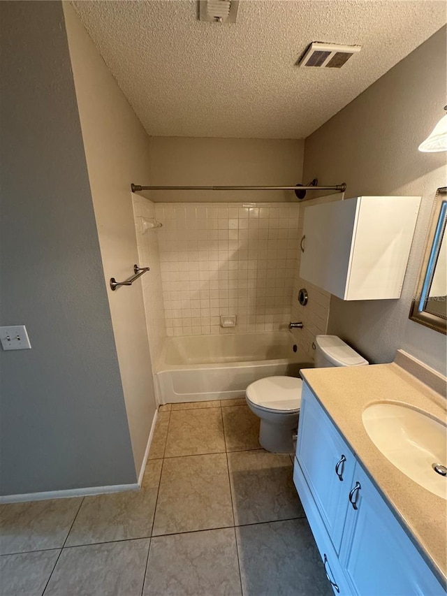 full bathroom featuring a textured ceiling, tile patterned floors, vanity, tiled shower / bath, and toilet