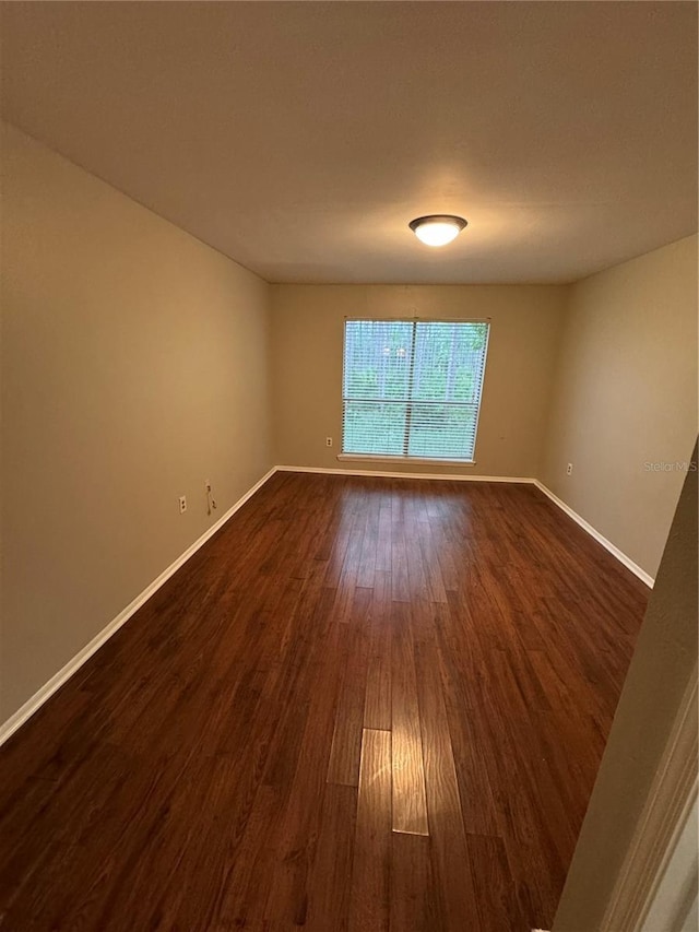 spare room featuring dark wood-type flooring