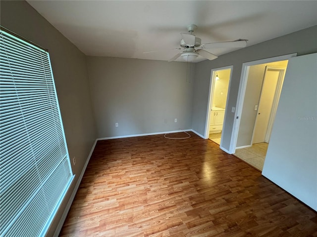 unfurnished bedroom featuring connected bathroom, light hardwood / wood-style floors, and ceiling fan