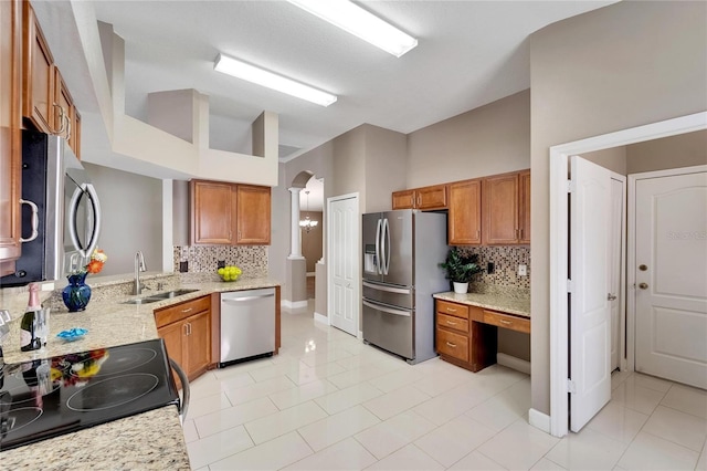 12739 Standbridge Dr, Riverview, FL 33579 - kitchen featuring stainless steel appliances, a sink, brown cabinets, decorative backsplash, and high vaulted ceiling