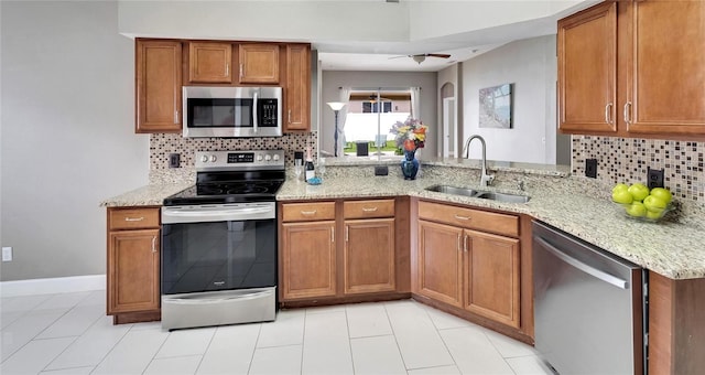 kitchen featuring appliances with stainless steel finishes, backsplash, kitchen peninsula, and sink