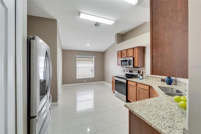 12739 Standbridge Dr, Riverview, FL 33579 - kitchen with stainless steel appliances, a sink, baseboards, and light stone countertops