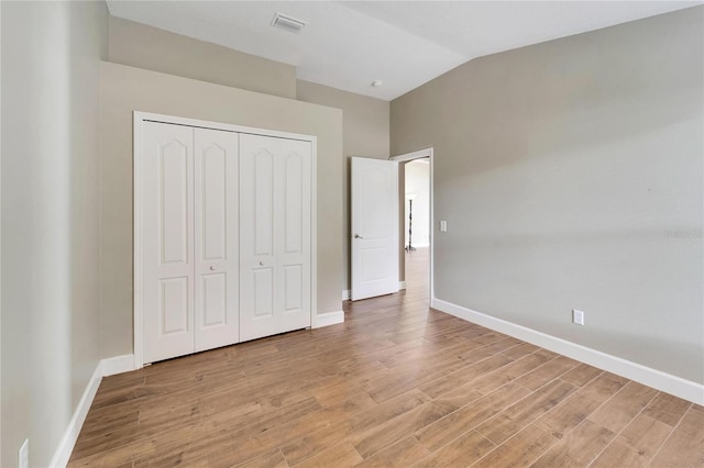 12739 Standbridge Dr, Riverview, FL 33579 - unfurnished bedroom featuring baseboards, light wood-style flooring, vaulted ceiling, and a closet