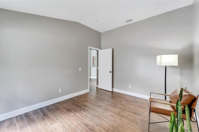 unfurnished room with lofted ceiling and light hardwood / wood-style flooring