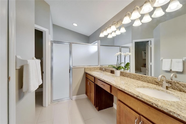 bathroom with walk in shower, vanity, vaulted ceiling, and tile patterned floors