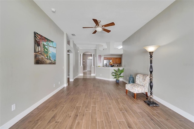 12739 Standbridge Dr, Riverview, FL 33579 - living area with arched walkways, ceiling fan, light wood-style floors, and baseboards