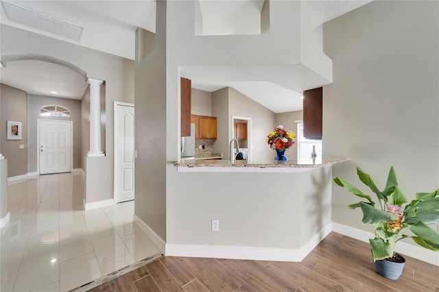 12739 Standbridge Dr, Riverview, FL 33579 - kitchen featuring ornate columns, freestanding refrigerator, light wood finished floors, a sink, and arched walkways