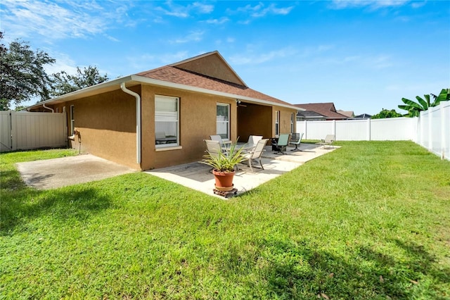 back of property featuring a yard and a patio area