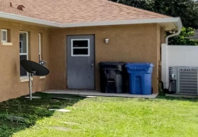 view of outbuilding with a lawn and cooling unit