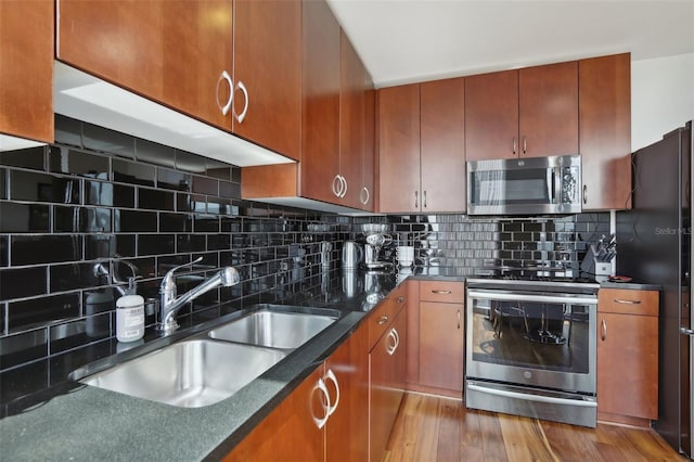 kitchen with backsplash, light hardwood / wood-style floors, sink, and stainless steel appliances