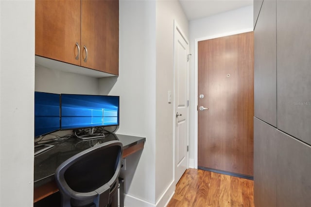 clothes washing area with cabinets and light hardwood / wood-style flooring