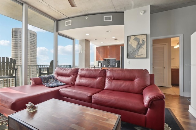 living room featuring a wall of windows, hardwood / wood-style floors, and ceiling fan