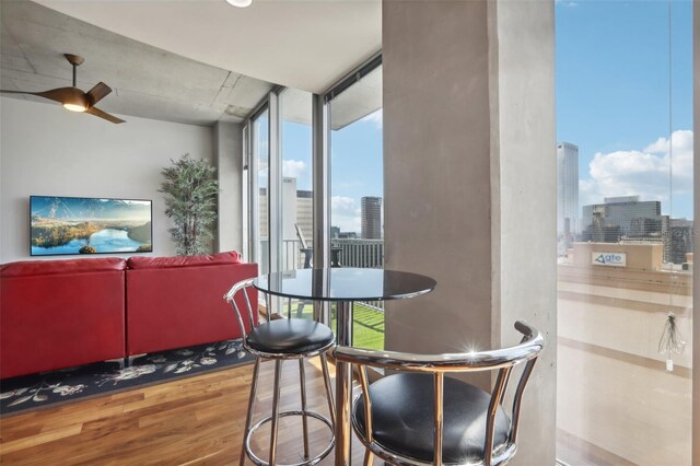 dining area with wood-type flooring, ceiling fan, and floor to ceiling windows