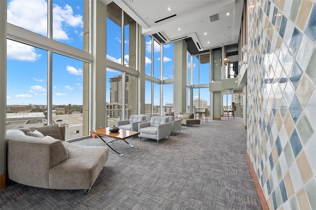 living room featuring a high ceiling, carpet flooring, and a wealth of natural light