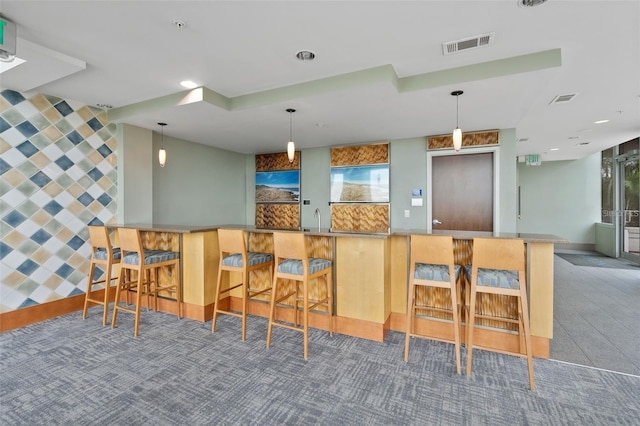 kitchen featuring carpet floors, a breakfast bar area, kitchen peninsula, and a wealth of natural light