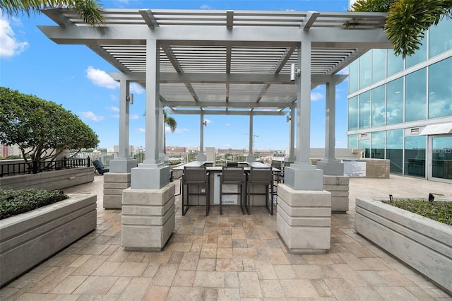 view of patio / terrace with a pergola, area for grilling, and a bar