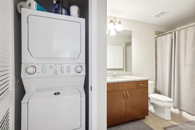 777 N Ashley Dr Unit 1606, Tampa, FL 33602 - bathroom featuring stacked washer / drying machine, vanity, tile patterned floors, toilet, and a shower with curtain