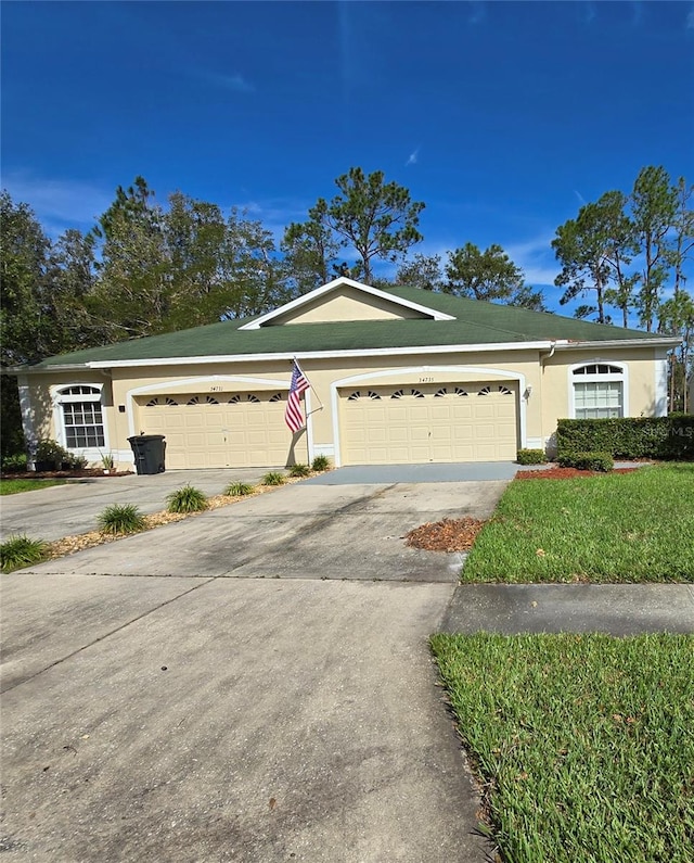 ranch-style home with a garage, concrete driveway, and stucco siding