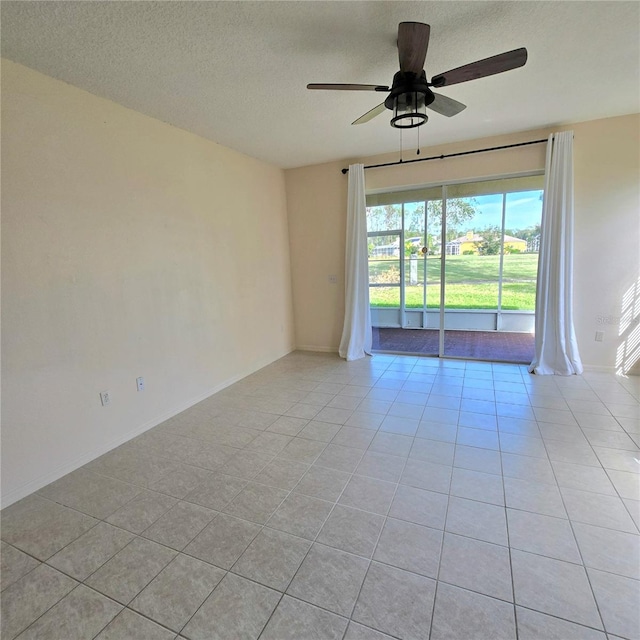 unfurnished room featuring a textured ceiling, ceiling fan, and light tile patterned floors