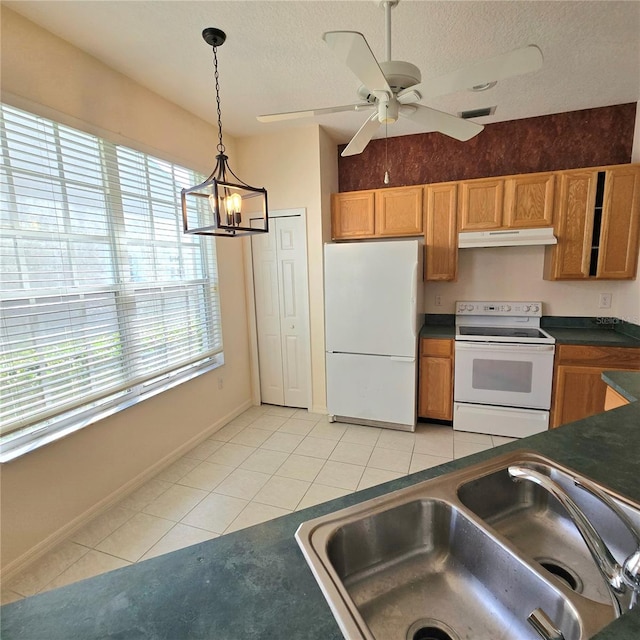 kitchen with sink, decorative light fixtures, light tile patterned floors, a textured ceiling, and white appliances