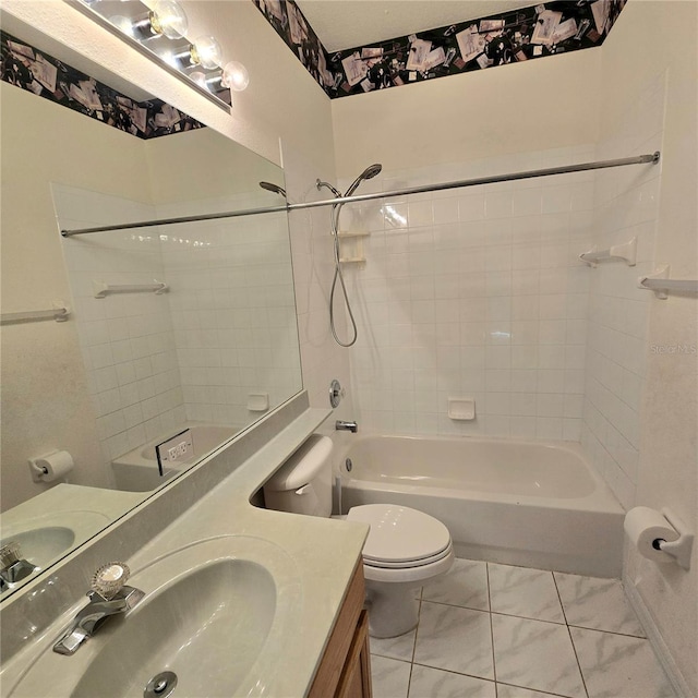 full bathroom featuring toilet, tiled shower / bath, vanity, and tile patterned flooring