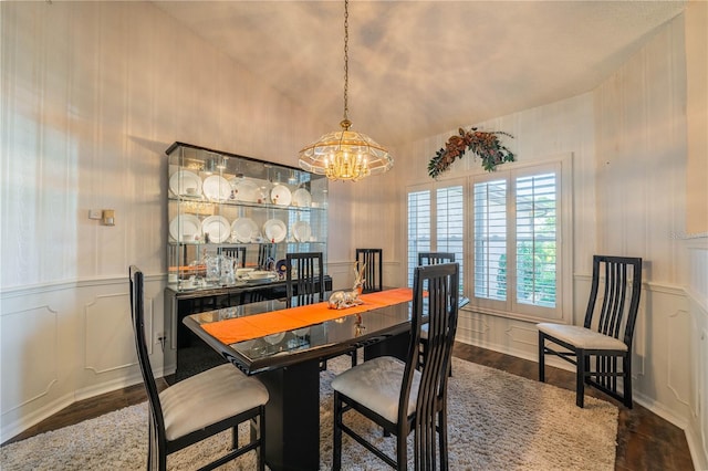 dining space with dark hardwood / wood-style floors and a chandelier