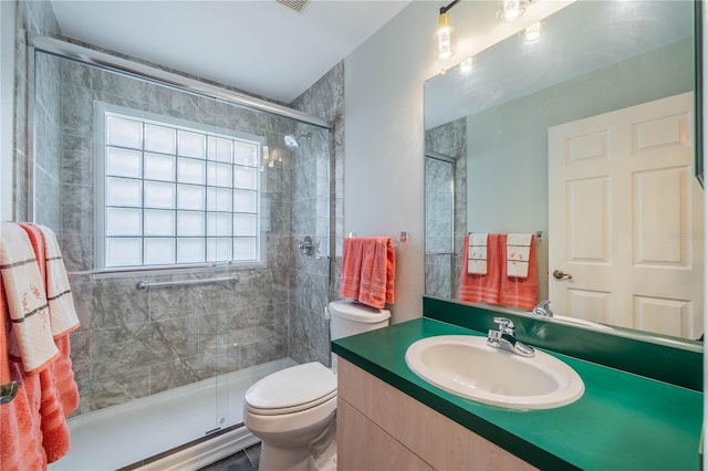 bathroom with a shower with door, toilet, and vanity