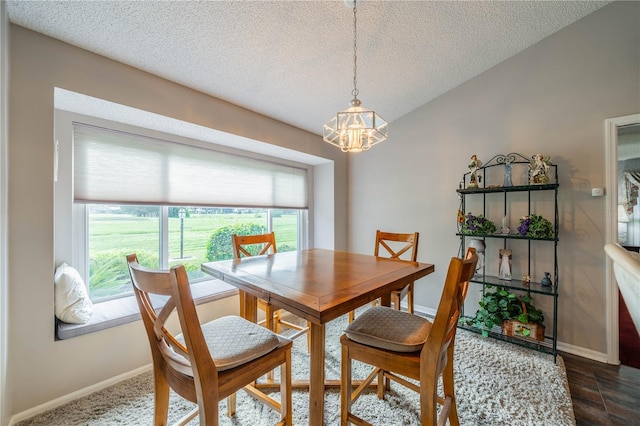 dining space with a textured ceiling and a notable chandelier