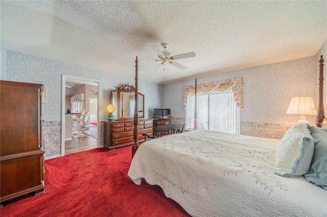 carpeted bedroom featuring ceiling fan and a textured ceiling