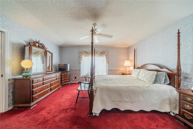 bedroom with ceiling fan, a textured ceiling, and dark colored carpet