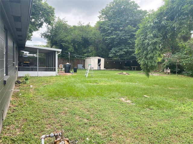 view of yard with a sunroom and a storage shed