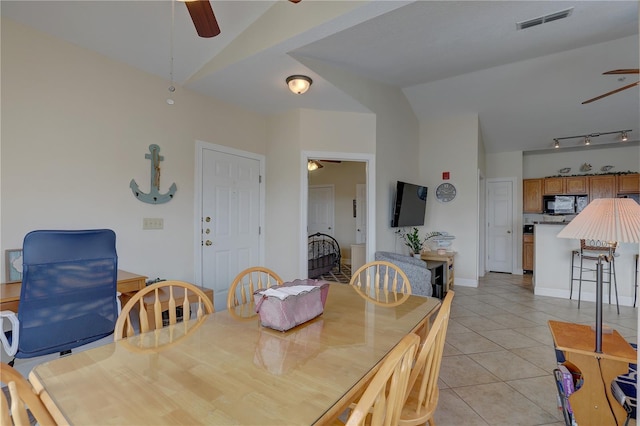 dining area with vaulted ceiling, ceiling fan, and light tile patterned floors