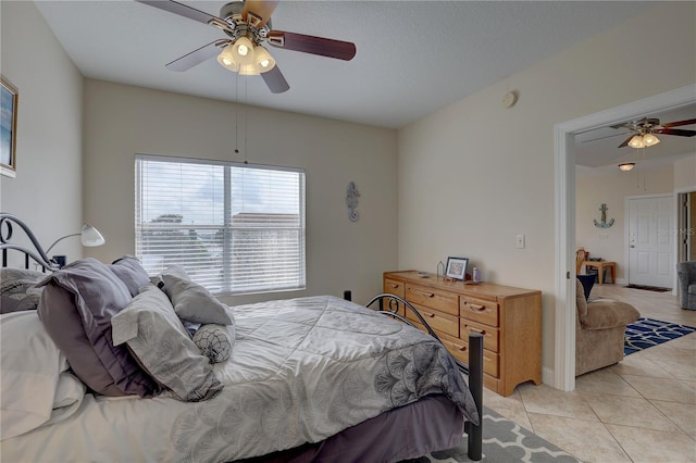 tiled bedroom with a textured ceiling and ceiling fan