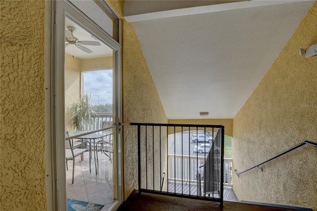 stairway featuring a textured ceiling and ceiling fan