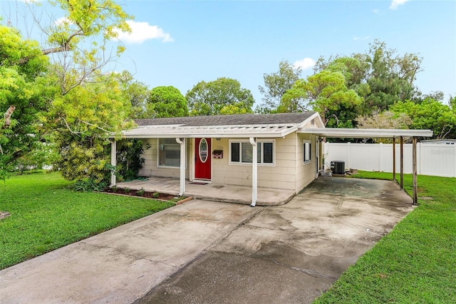 single story home with covered porch, a front lawn, central air condition unit, and a carport