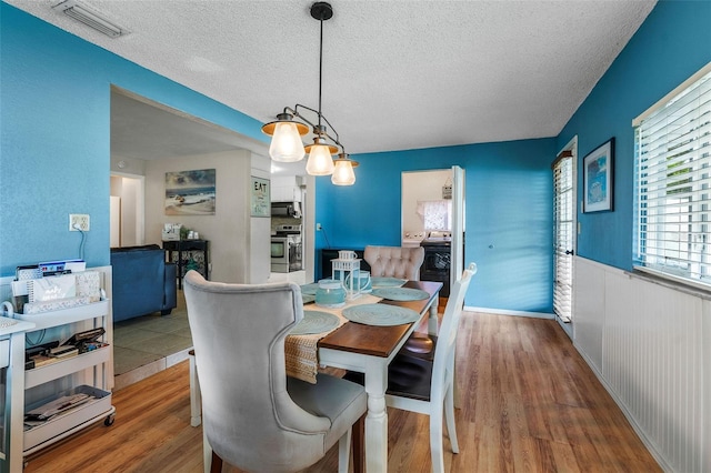 dining area featuring a textured ceiling and hardwood / wood-style flooring