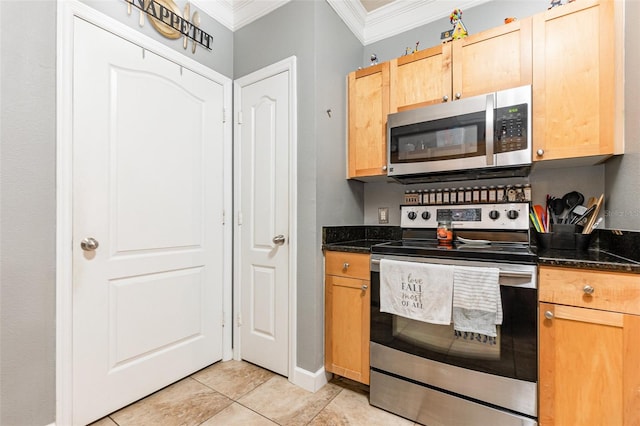 kitchen featuring light tile patterned floors, appliances with stainless steel finishes, ornamental molding, and dark stone counters