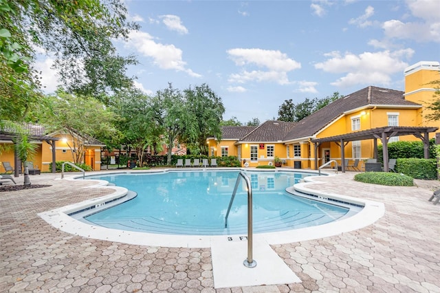 view of swimming pool with a patio and a pergola