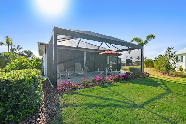 back of house featuring a lanai, a patio area, and a lawn