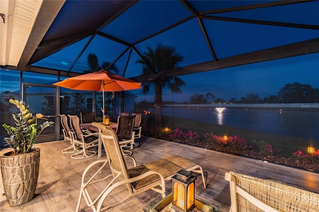 patio at twilight with a water view and a lanai