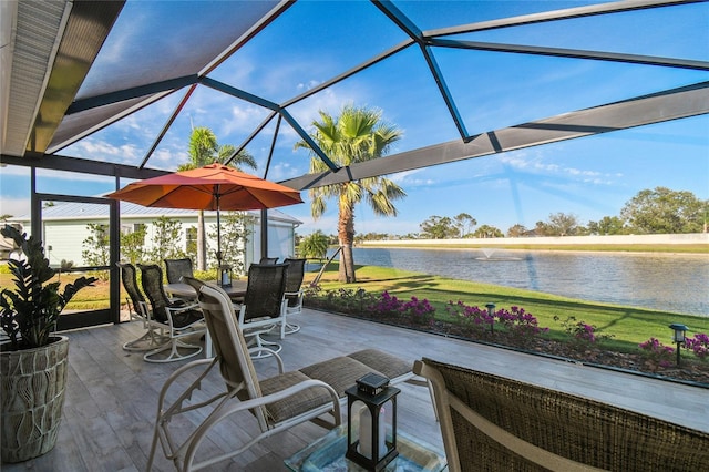 view of patio featuring glass enclosure and a water view