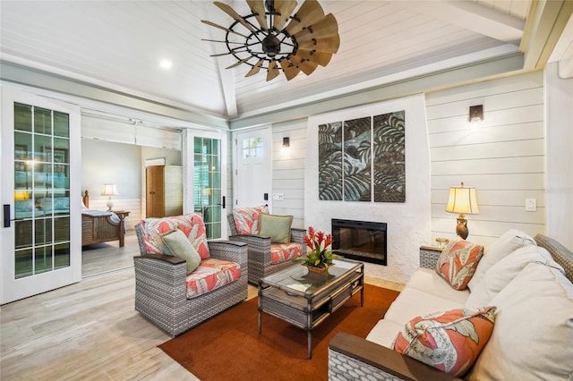 living room with wood ceiling, vaulted ceiling with beams, a premium fireplace, and hardwood / wood-style floors