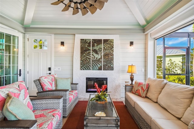 living room with lofted ceiling with beams, a wealth of natural light, ceiling fan, and dark hardwood / wood-style flooring