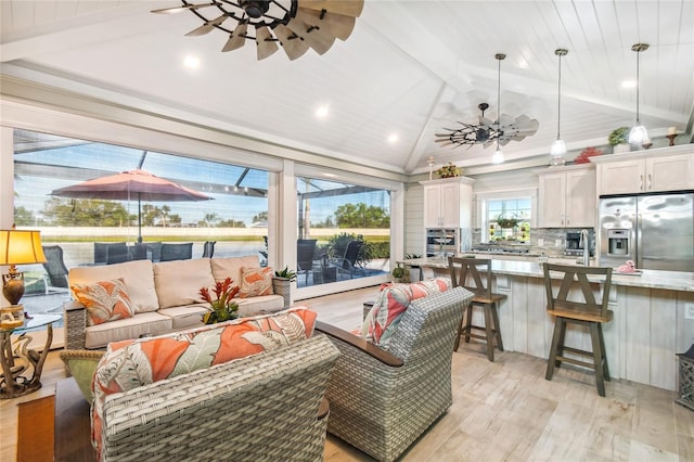 living room featuring ceiling fan, vaulted ceiling with beams, wood ceiling, and light hardwood / wood-style floors