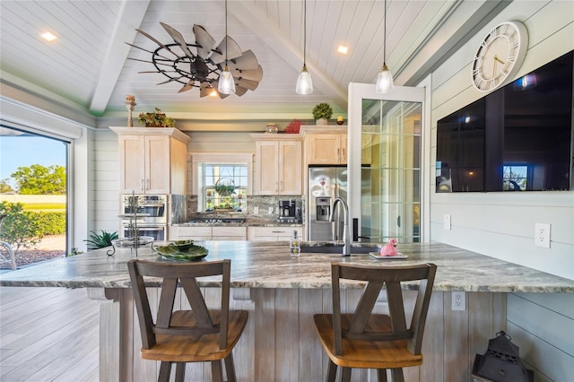 kitchen with ceiling fan, a kitchen breakfast bar, and plenty of natural light