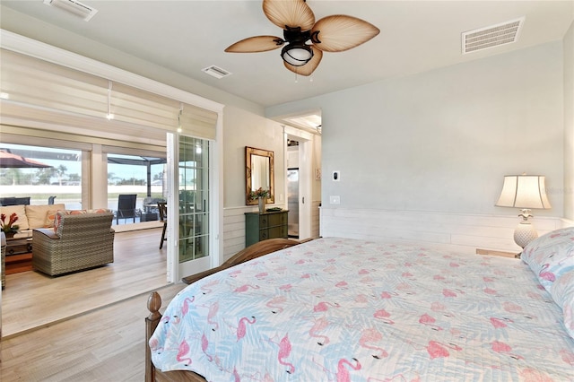 bedroom with hardwood / wood-style floors, ceiling fan, and access to exterior