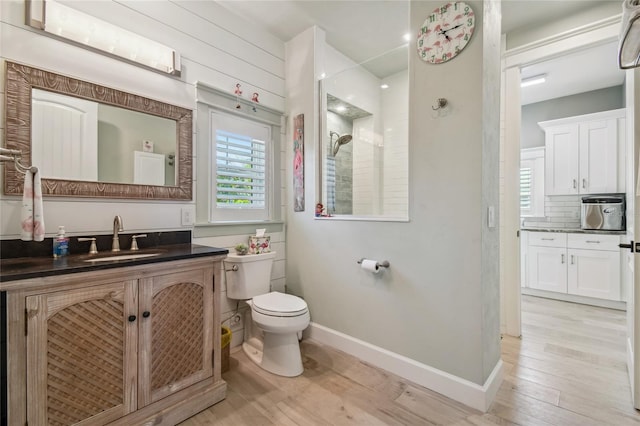 bathroom featuring a shower, hardwood / wood-style flooring, vanity, and toilet