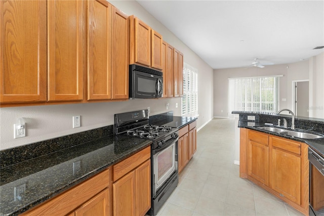 kitchen with dark stone countertops, ceiling fan, sink, and black appliances