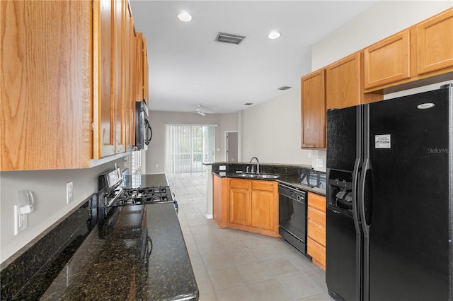 kitchen with black appliances, dark stone countertops, sink, and ceiling fan