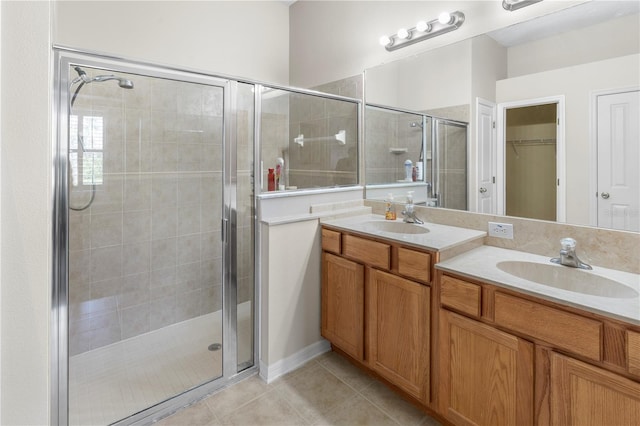 bathroom featuring tile patterned floors, an enclosed shower, and vanity